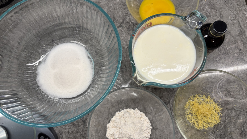 Mise en place for egg custard: sugar, egg yolks, milk, flour, lemon zest, vanilla extract